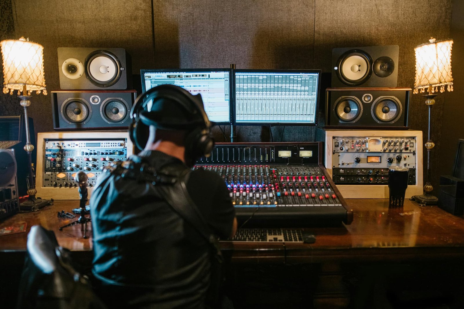 a man in headphones sitting in front of a sound mixer