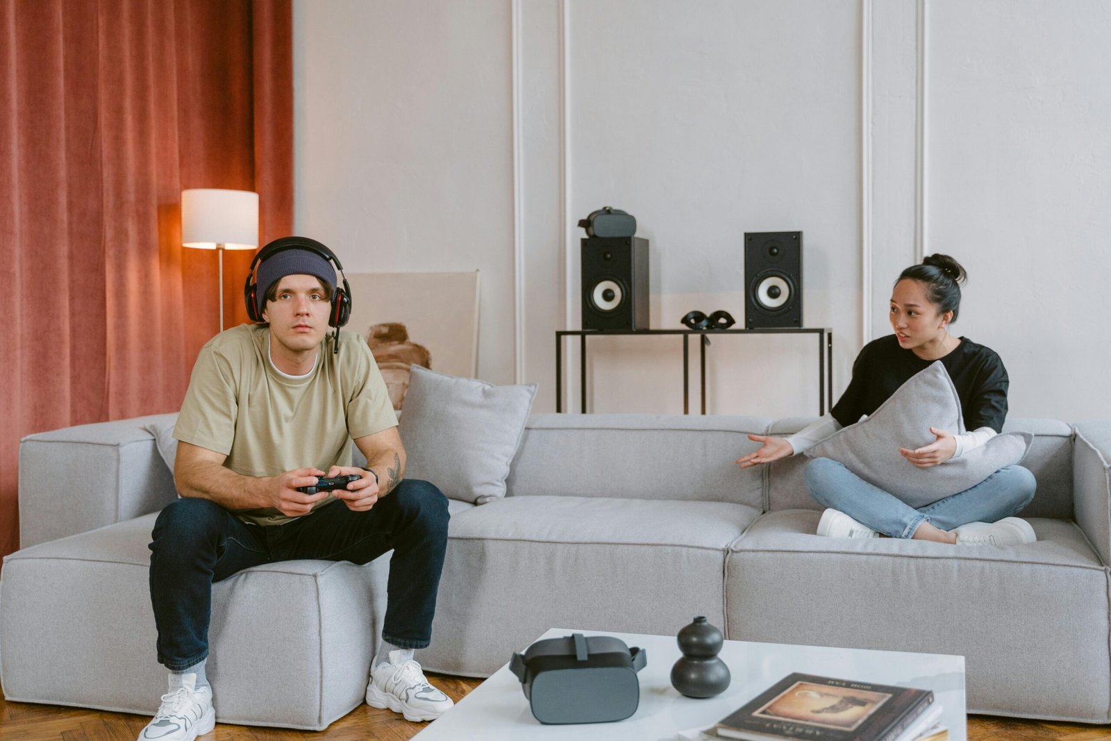 Couple engaging in video gaming in a modern living room setting, highlighting leisure and technology.